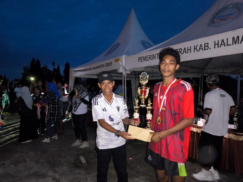 Kadispora Haltim, Niksen Malicang serahkan Tropi dan Bonus kepada Juara I Volly Putra (dok/Googira)